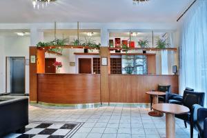 a lobby with a waiting area with potted plants at Attic Hotel in Prague