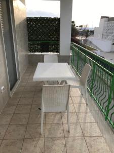 een witte tafel en 2 stoelen op een balkon bij B&B Oleum in Terlizzi
