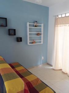 a bedroom with a bed with a colorful blanket at Residencial Praia dos Corais in Coroa Vermelha