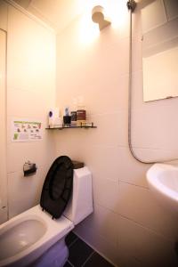 ソウルにあるコステイ ゲストハウス ソウル ステーションのバスルーム(トイレ、黒い椅子、シンク付)