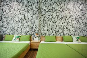 a living room with two green couches in front of a wallpaper at Nẫu House in Tuy Hoa +101 photos