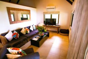 a living room with a couch and a tv at Qamea Resort & Spa in Qamea