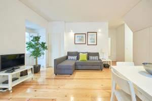 a living room with a couch and a tv at Casa Eclea Lisbon Principe Real in Lisbon