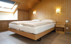 una camera con due letti in una stanza con pareti in legno di Rössli Holiday Apartment a Interlaken