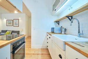 a kitchen with white cabinets and a sink at Casa Eclea Lisbon Principe Real in Lisbon +20 photos
