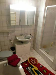 a bathroom with a sink and a toilet and a shower at Ferienwohnung Bozsik in Schweinfurt