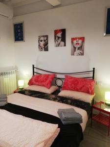 two beds in a room with pictures on the wall at B & B Eliana in Florence