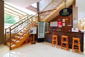 a restaurant with a staircase and two stools at Ombey Guest House in Bogor