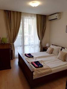 a bedroom with a large bed with two towels on it at Private Apartment 49 in Prestige Fort Beach Hotel in Sveti Vlas