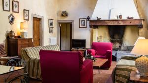 a living room with two chairs and a fireplace at Tenuta di Ghizzano Resort in Ghizzano