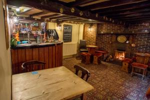 a bar with a wooden table and a fireplace at The Black Horse Inn in Louth
