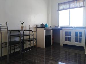 eine Küche mit einem Tisch und Stühlen im Zimmer in der Unterkunft Seaview Mansion Apartment 1 in Dalaguete
