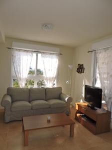 sala de estar con sofá y TV en La Manga Apartments - Punta Cormoran, en La Manga del Mar Menor