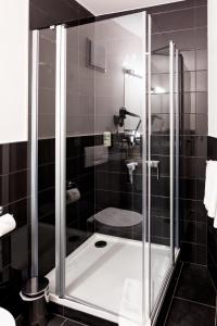 a bathroom with a shower with a tub at Hotel Anna in Stendal