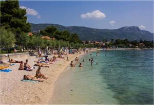 a group of people on a beach in the water at Barać in Kaštela