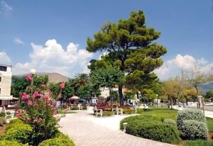 a park with tables and chairs and a tree at Barać in Kaštela +2 photos