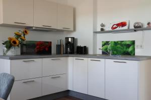 uma cozinha com armários brancos e um lavatório em galerie 65 em Nettetal