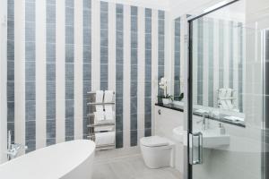 
a bathroom with a shower, toilet, sink and tub at The Rutland Hotel & Apartments in Edinburgh
