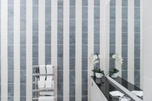 een badkamer met een witte en grijze tegelmuur bij The Rutland Hotel & Apartments in Edinburgh