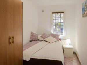 Dormitorio pequeño con cama y ventana en Apartment south en Darłowo