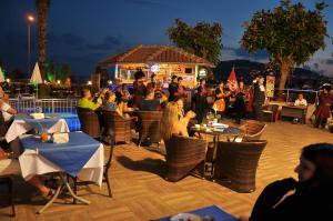 Un grupo de personas sentadas en mesas en un restaurante. en Parador Beach Hotel All Inclusive, en Alanya