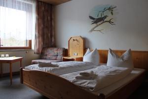 1 dormitorio con 1 cama, 1 silla y 1 ventana en Hotel Waldfrieden, en Elsterberg