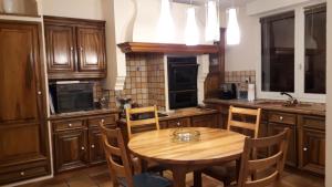 eine Küche mit Holzschränken und einem Holztisch in der Unterkunft Villa avec vue in Biviers
