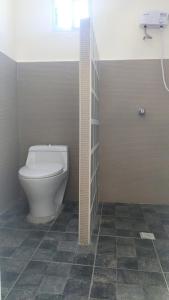 a bathroom with a toilet and a tile floor at Seaview Mansion Dalaguete Apartment 3 in Dalaguete