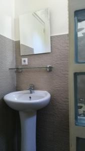 a bathroom with a white sink and a mirror at Seaview Mansion Dalaguete Apartment 3 in Dalaguete
