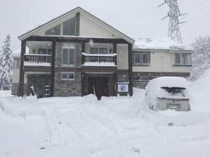 a house with a pile of snow in front of it at Legend Inn Myoko in Myoko
