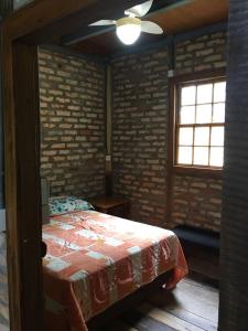 1 dormitorio con 1 cama y ventilador de techo en Pousada Bergen Hütten en Rio Fortuna