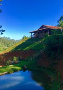 een huis bovenop een heuvel naast een meer bij Pousada Bergen Hütten in Rio Fortuna