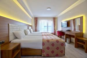 a hotel room with a large bed and a desk at Bolu Suit Otel in Bolu