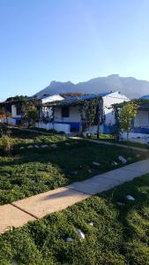 a house with a sidewalk next to a grass field at Ferma Jebala Ecolodge in Kitane