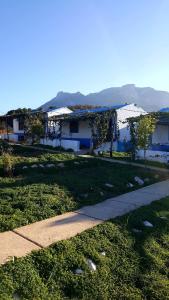 une maison avec un trottoir à côté d'une pelouse dans l'établissement Ferma Jebala Ecolodge, à Kitane