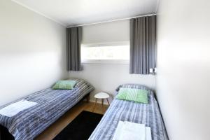 2 camas en una habitación pequeña con ventana en Nallikari Holiday Village Villas en Oulu