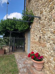 un edificio de piedra con dos macetas de flores al lado de una puerta en Casa di Romano, Al Tramonto en Marcialla