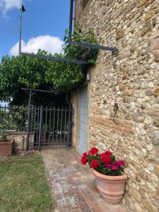 a stone building with two pots of flowers next to a door at Casa di Romano, Al Tramonto in Marcialla