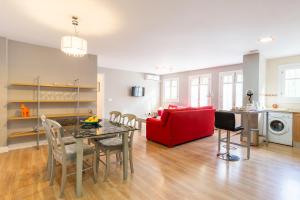 a living room with a table and a red couch at Mundo Nuevo: Acogedor Apartamento en el Centro in Málaga