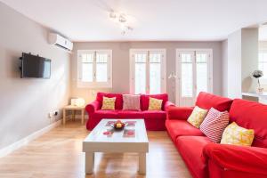 a living room with a red couch and a table at Mundo Nuevo: Acogedor Apartamento en el Centro in Málaga