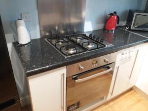 a kitchen with a stove and a counter top at Mersey View, Two Bedroom Apartment, Liverpool in Waterloo