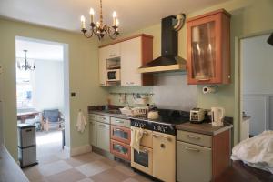 a kitchen with wooden cabinets and a stove top oven at Tottenham Stadium double room in London