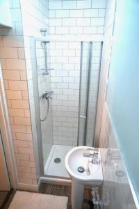 a bathroom with a shower and a white sink at Tottenham Stadium double room in London