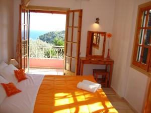 a bedroom with a bed and a view of the ocean at Ipsia Apartments in Paleokastritsa