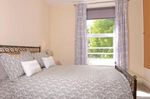 um quarto com uma cama e uma janela em Jevington Gardens em Eastbourne