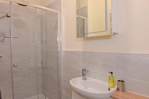 uma casa de banho com um lavatório e um chuveiro em Jevington Gardens em Eastbourne