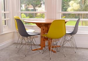 uma mesa e quatro cadeiras num quarto com janelas em Jevington Gardens em Eastbourne