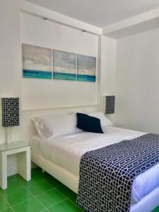 um quarto com uma cama com um cobertor azul e branco em Sorrento Olive Tree Garden em Sorrento