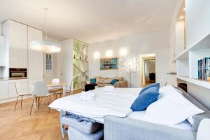 un salon avec un lit et une salle à manger dans l'établissement Central and Luxurious Beethovnova Apartment, à Ljubljana