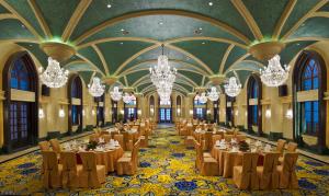 una sala banchetti con tavoli, sedie e lampadari a braccio di Royal Grace Hotel Optics Valley Wuhan a Wuhan